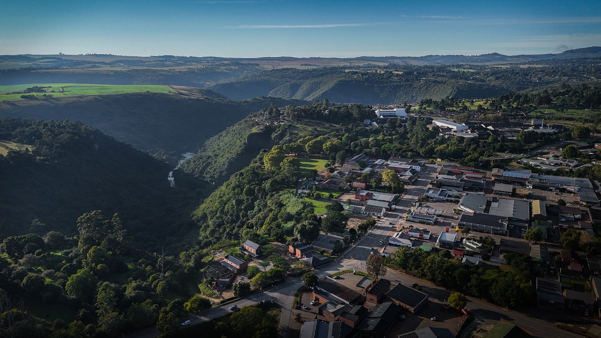 Aerial view of a town beside a forested gorge
